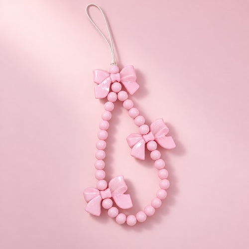 a pink bow beaded charm strap