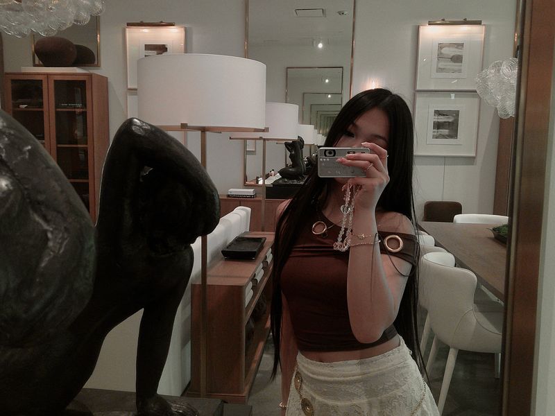 a girl taking a mirror selfie in a showroom