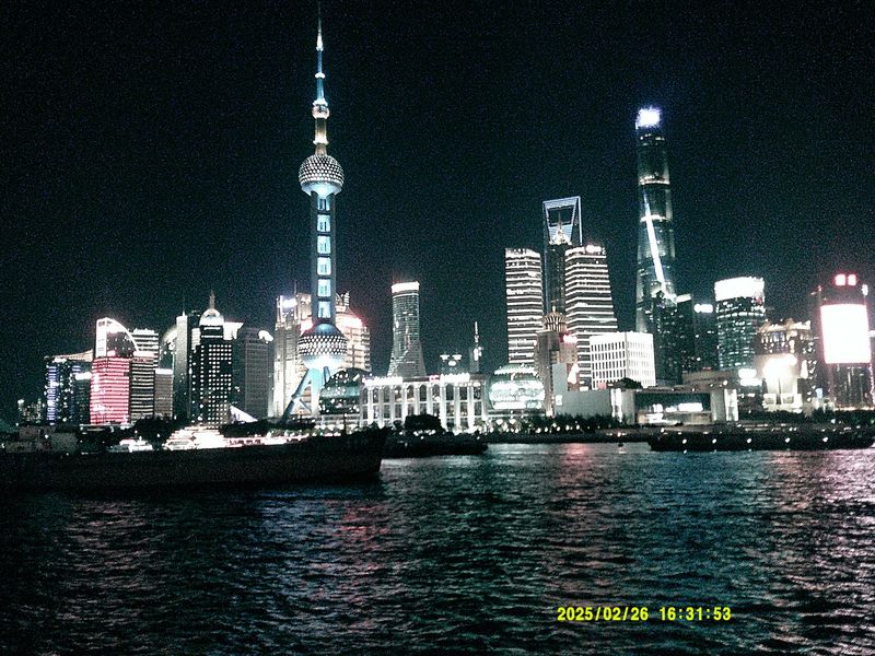 a river skyline with a tall tower at night